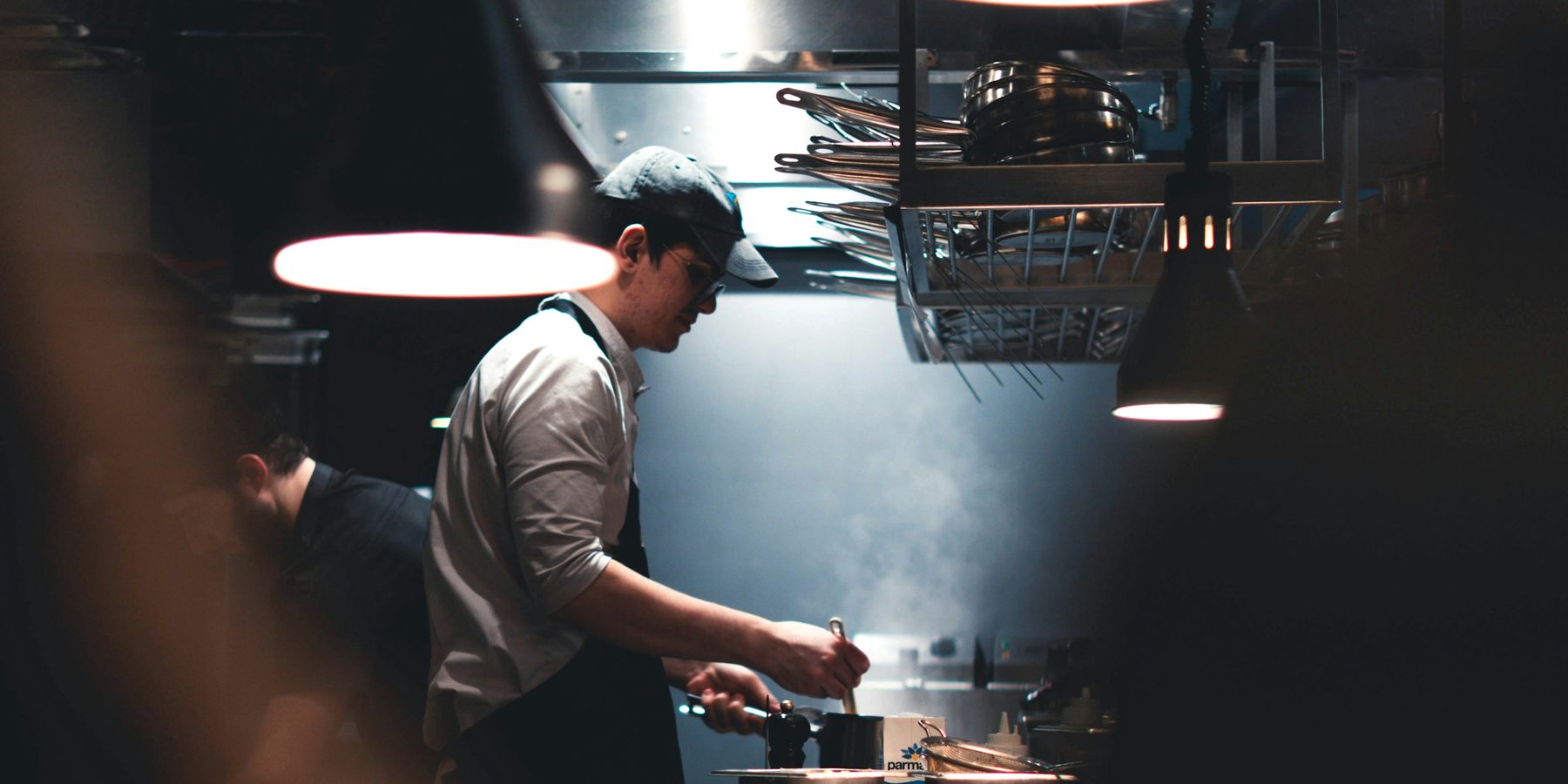 Cozinheiro preparando um prato durante o serviço em uma cozinha profissional